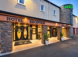 Una recepción de hotel con fachada de piedra, un restaurante y un letrero que dice 'The Hedge'.
