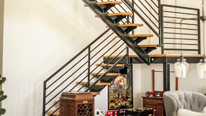 A modern interior with a wooden staircase, a dining area, and a seating area. - The Lucky Penny Farmhouse on the LBJ Grasslands (Alvord)