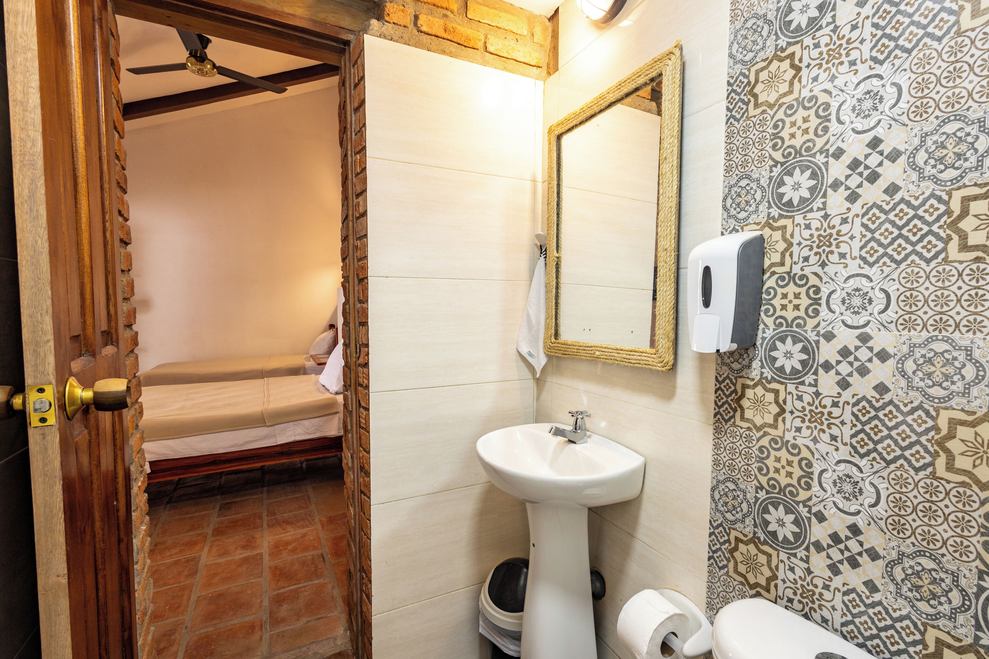 A bathroom with a sink, toilet, and a mirror.