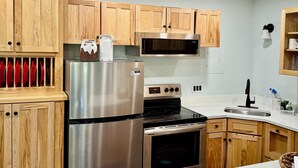 A modern kitchen with wooden cabinets, stainless steel appliances, and a marble countertop. - Recently Renovated Ski In-Out on Purgatory Mountain (Durango)