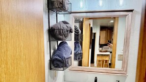 A bathroom with a wooden herringbone cabinet, a white marble sink, and a mirror above the sink. - Recently Renovated Ski In-Out on Purgatory Mountain (Durango)
