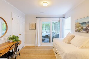 A bedroom with a bed, a desk, and a chair. There is a window with curtains, a door, and a picture on the wall. - Coastal Retreat-4B/2B 9ppl 3 mi to IOP fenced yard (Mount Pleasant)