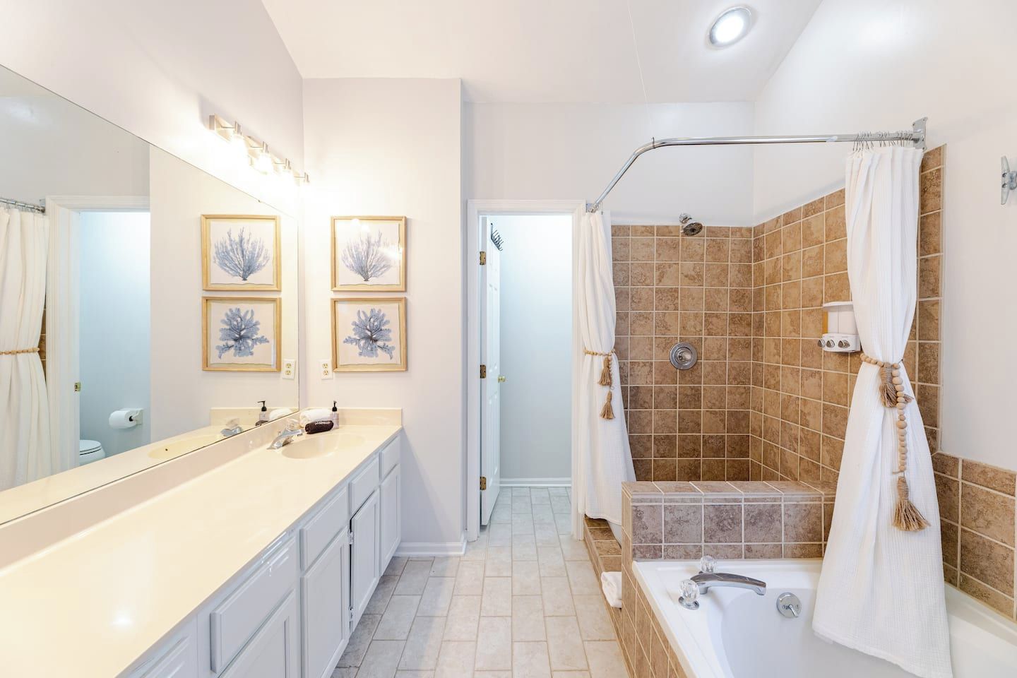 A modern bathroom with a bathtub, shower, and a vanity with a mirror.