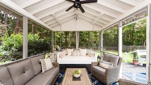 A covered outdoor seating area with a sofa, chairs, and a coffee table. - Clean Coastal Cottage 5min to beach & 20 min to Charleston (Mount Pleasant)