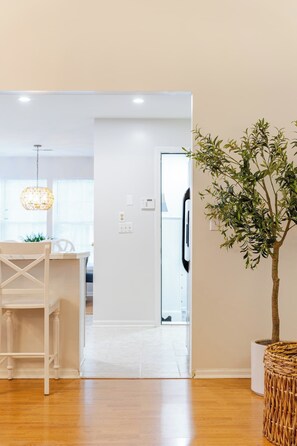Een modern interieur met een houten eettafel, een hanglamp en een potplant.