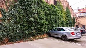 En parkeringsplats intill en byggnad med en grön, murgrönebeklädd vägg.