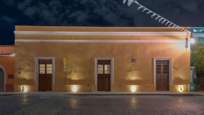A building with three wooden doors and a cobblestone street in front. - La Ermita Suites in Merida Centro with Pool - Historic Church Front (Centro)