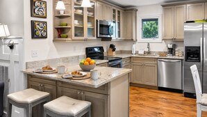 A modern kitchen with a central island, stainless steel appliances, and a view of the outdoors. - Pet Friendly, Walk to beach, pool and community dock and more! (Kiawah Island)