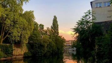 A calm river with trees and a building on the right.