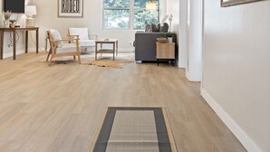 A modern living room with a wooden floor, a sofa, a chair, a coffee table, a TV, and a framed artwork on the wall. - Outpost: Town Square Lodge 8 - Close to Town Square (Jackson)