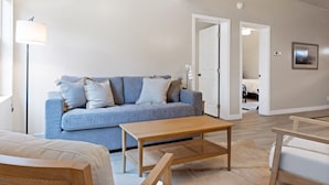 A modern living room with a blue sofa, wooden coffee table, and a lamp. - Outpost: Town Square Lodge 8 - Close to Town Square (Jackson)
