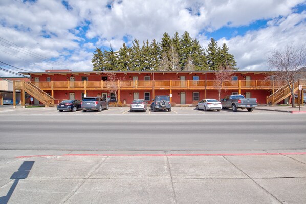 A motel with a two-story structure, multiple parking spaces, and a clear view of the surrounding area. - Outpost: Town Square Lodge 11 - Close to Town Square (Jackson)