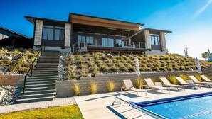 A modern two-story house with a swimming pool, a staircase leading to the upper level, and a landscaped garden. - Private Pool | Stunning lake & mountain views | Modern, costal design (Manson)