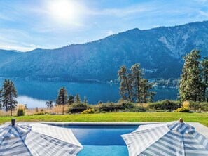 A swimming pool with a view of a lake and mountains in the background. - Private Pool | Stunning lake & mountain views | Modern, costal design (Manson)