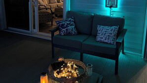 A cozy living room with a sofa, a coffee table with candles, and a wall-mounted sign.