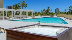 A rooftop pool with a hot tub, lounge chairs, and a covered seating area. - Waikiki Ocean&Sunrise View Studio (Honolulu)