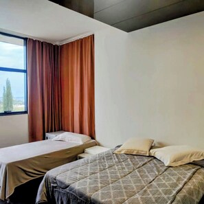 Quarto conforto, várias camas, banheiro privativo, vista para a cidade | Frigobar, escrivaninha, espaço de trabalho para notebook