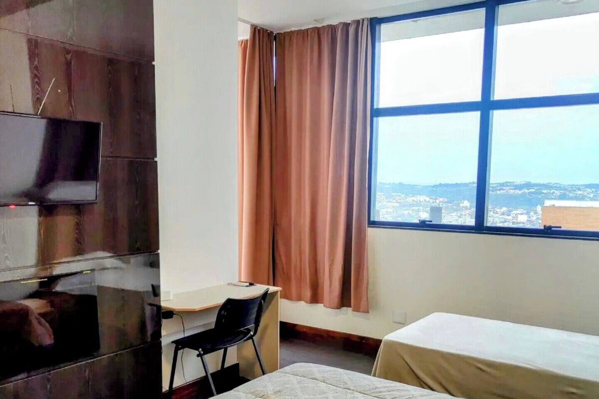 Quarto conforto, várias camas, banheiro privativo, vista para a cidade | Frigobar, escrivaninha, espaço de trabalho para notebook