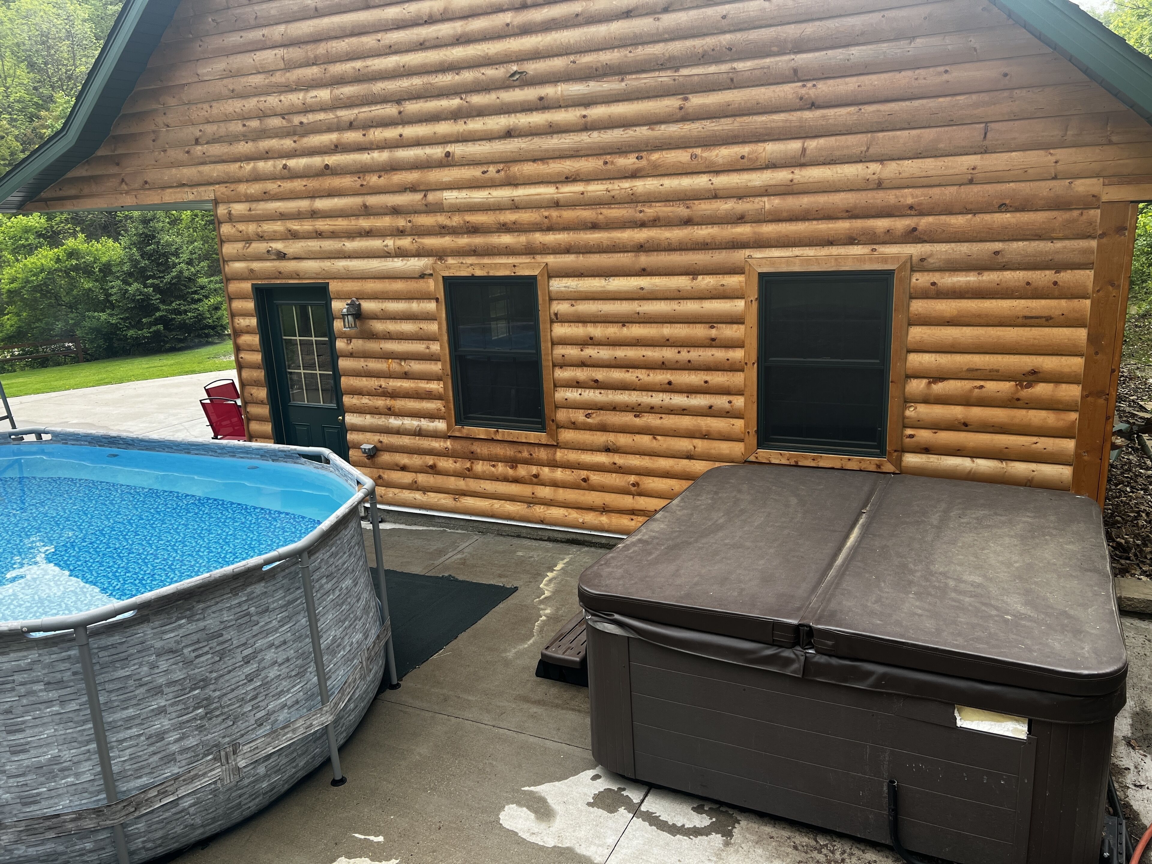 A log cabin with a swimming pool and a hot tub.