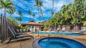 A pool area with lounge chairs, a small building, and palm trees. - Tropical Kihei Resort, 3 Min Walk to Beach, A/C in All Rooms (Kihei)