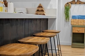 Eine Bar mit hölzernen Barhocker und einer Theke.