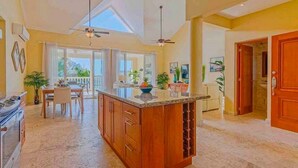 A spacious kitchen with a central island, large windows, and a dining area with a view. - Beachfront residence in central Sosua, 2BD/2BTH with sea views. Chica-friendly! (Sosúa)
