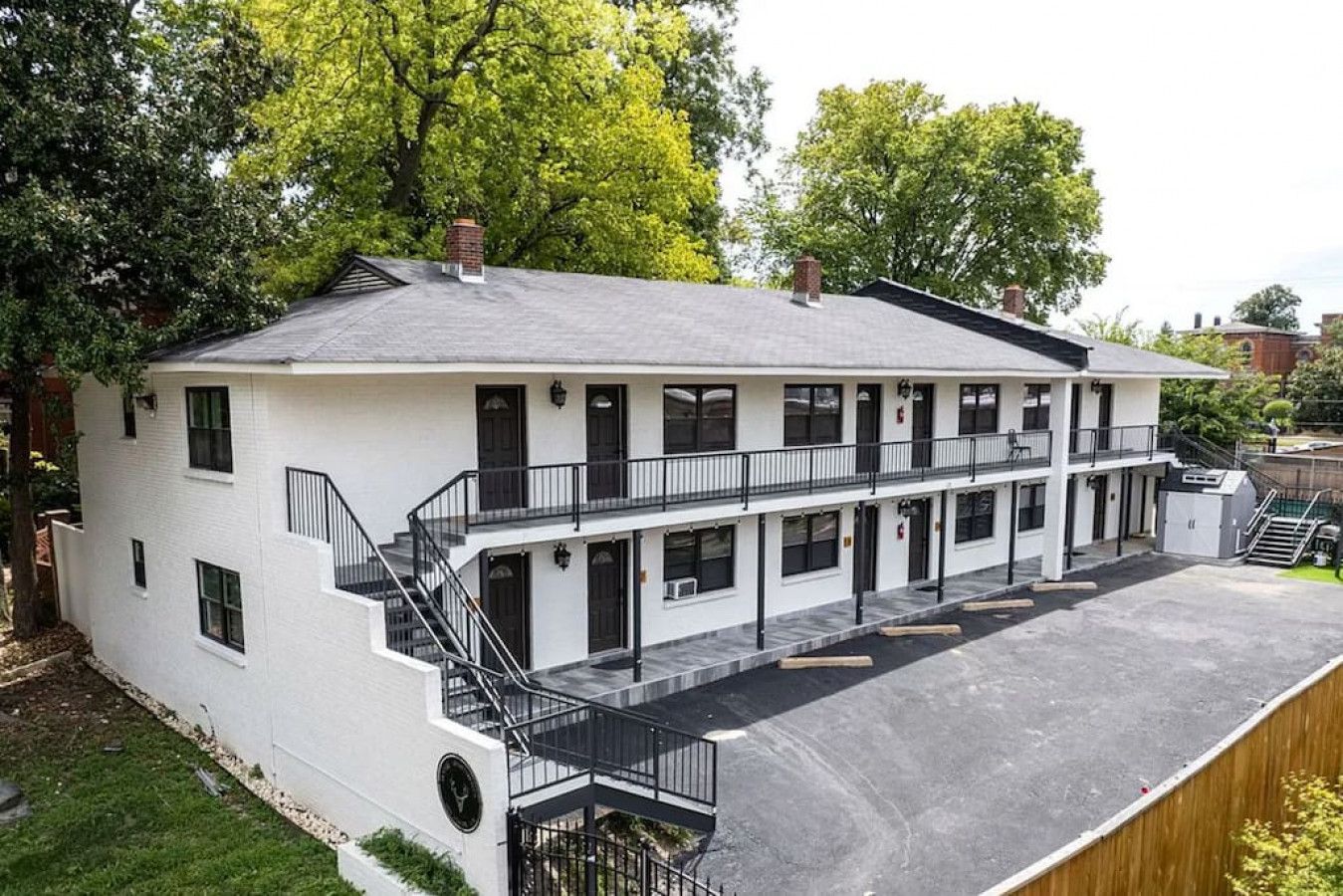 Un bâtiment à deux étages, doté d’un toit plat, de nombreuses fenêtres et d’un espace de stationnement couvert.