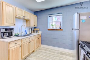 A kitchen with wooden cabinets, a built-in oven, and a window with a view.