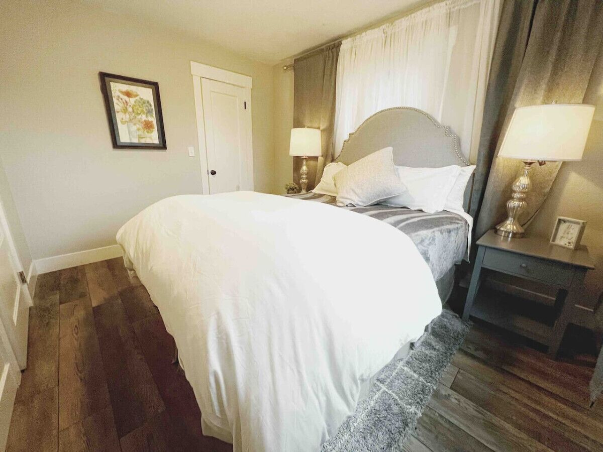 Cozy guest bedroom featuring a plush queen-sized bed with soft linens, ambient lighting, and a tranquil design that promises a restful stay. Perfect for relaxing after a day of exploring