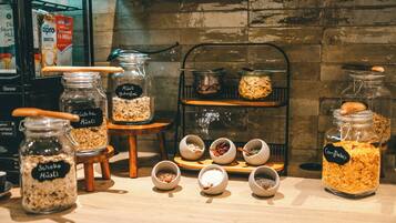 A variety of food items displayed in jars and bowls on a wooden counter.