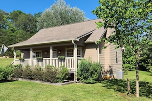 A two-story house with a front porch, a covered entryway, and a small front yard.