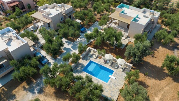 An aerial view of a residential area with multiple buildings, a swimming pool, and surrounding greenery. - Villa Artemis, a modern, comfortable home surrounded by Cretan nature (Rethimno)