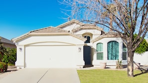 A single-story house with a garage, a front porch, and a small front yard. - Gilbert Ranch Retreat & Non Heated Pool. Walk to Shops and Restaurants. (Gilbert)