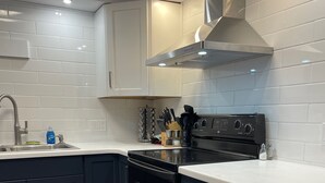 Een moderne keuken met donkere kastjes, een roestvrijstalen afzuigkap en een inbouwoven.