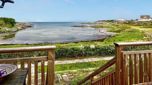 A coastal view from a wooden deck overlooking a rocky shoreline with a clear sky. - 3 bedroom awesome home in Vallda (Vallda)