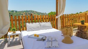 A bed with white linens, a tray with orange juice, and towels with 'ruralida' branding. - Villa Gamor Frigiliana by Ruralidays (Málaga)