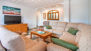 A living room with a sofa, a television, a wooden cabinet, and a checkered floor. - 5 bedroom amazing home in Cartagena (Cartagena)