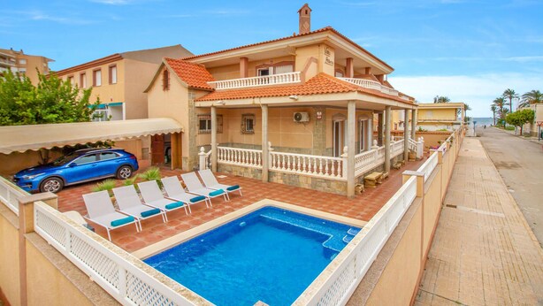 A two-story house with a swimming pool, a covered patio, and a blue car parked outside. - 5 bedroom amazing home in Cartagena (Cartagena)