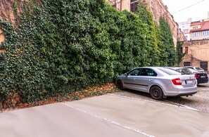 Ein Parkplatz neben einem Gebäude mit einer grünen Wand, die mit Efeu bewachsen ist.