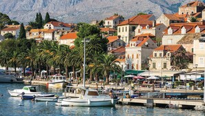 A coastal town with stone buildings, a marina with boats, and a mountainous backdrop. - Amazing home in Cavtat (Cavtat)