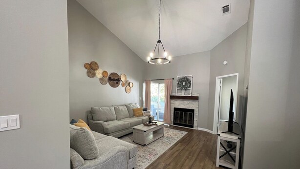 Una sala de estar con sofá, mesa de centro y chimenea.