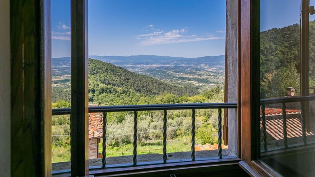 Uma varanda com vista para uma paisagem montanhosa.
