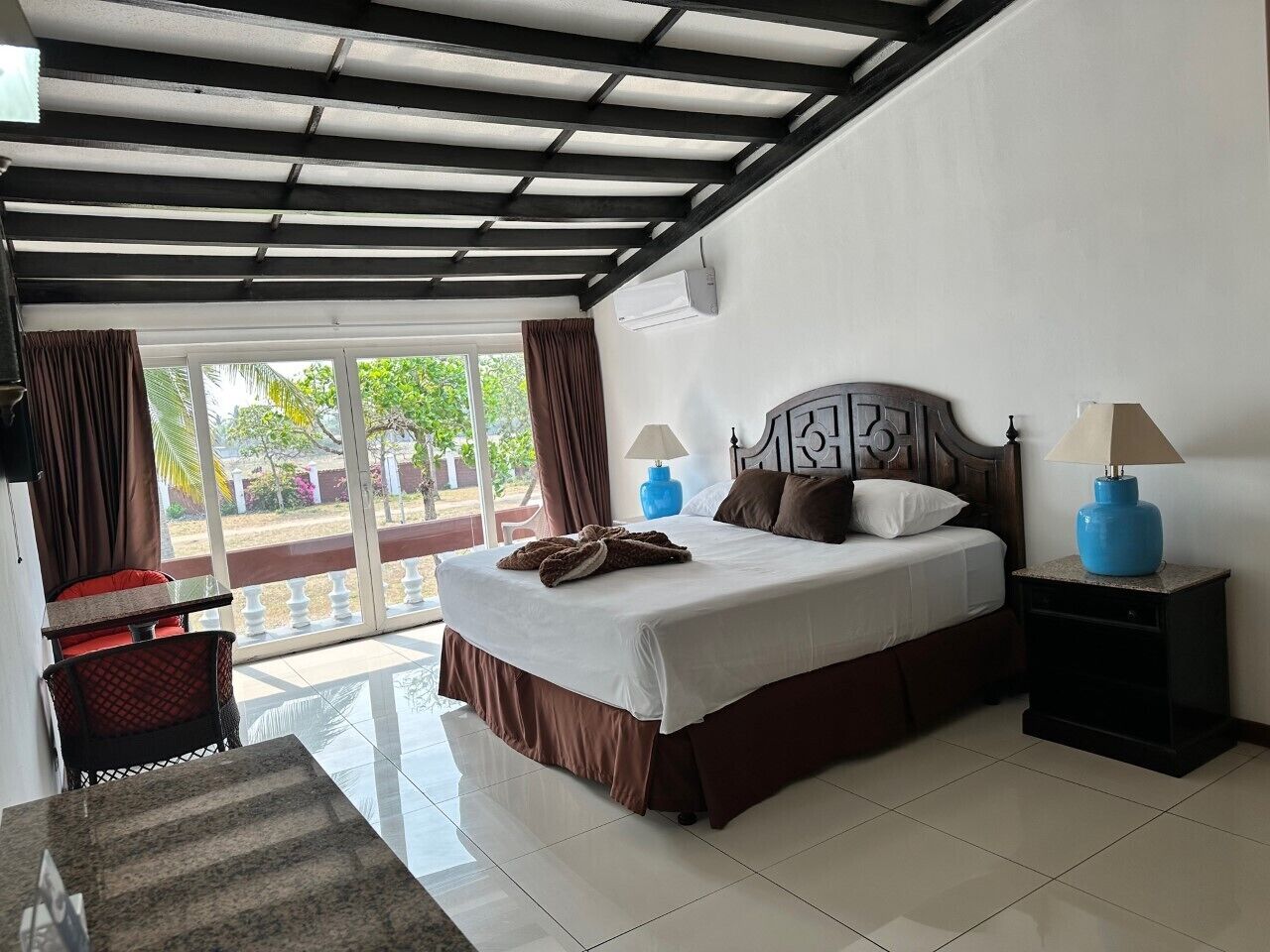 Une chambre d’hôtel avec un lit, une table de chevet, une chaise et une vue sur l’extérieur.