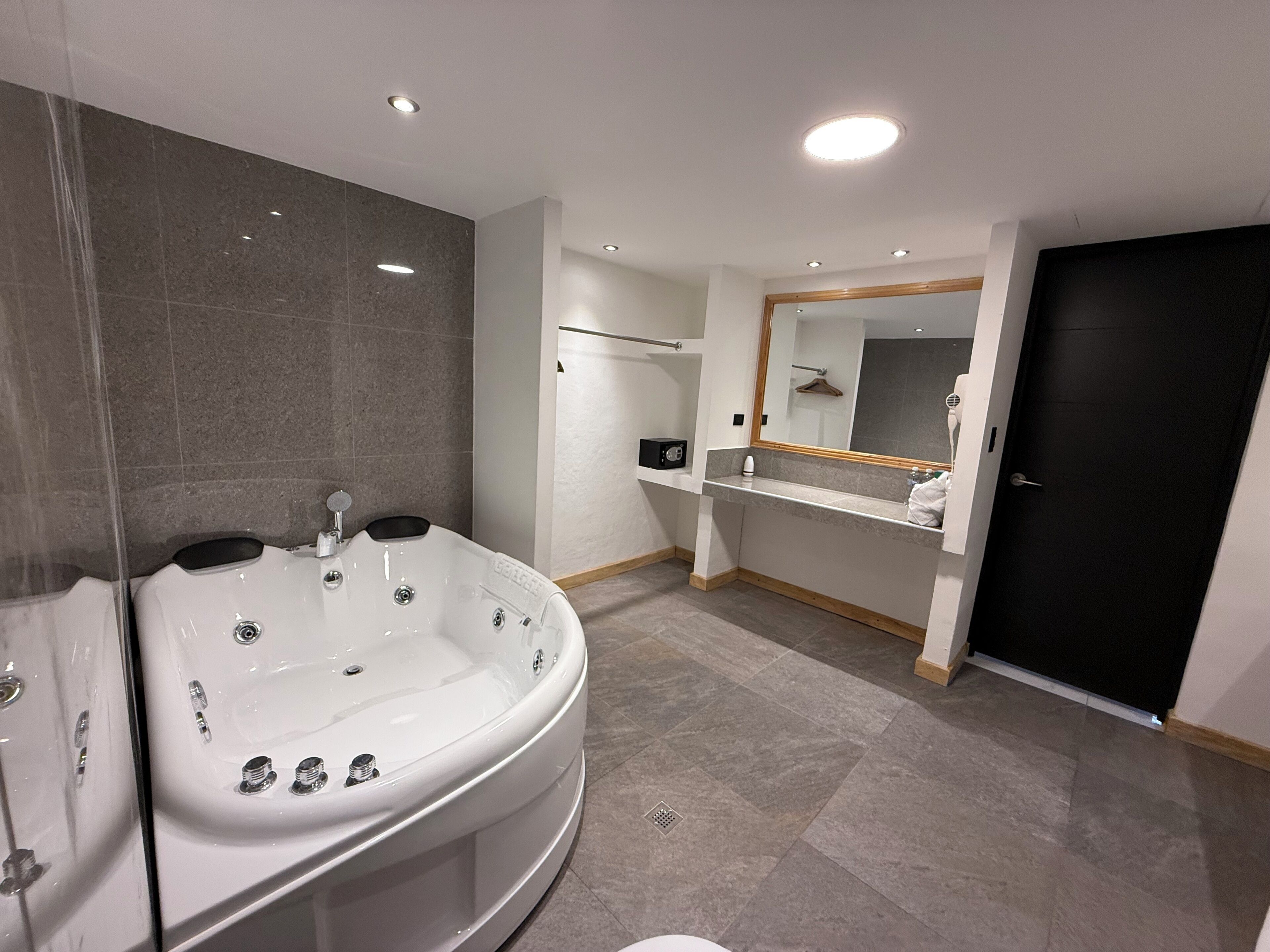 Un baño moderno con una bañera independiente, un tocador con espejo y una zona de ducha.