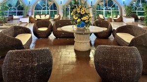 A spacious lobby with high ceilings, a large chandelier, and comfortable seating areas. - HOTEL TESORO BEACH (La Herradura)