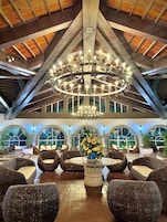 A spacious lobby with high ceilings, a large chandelier, and comfortable seating areas.