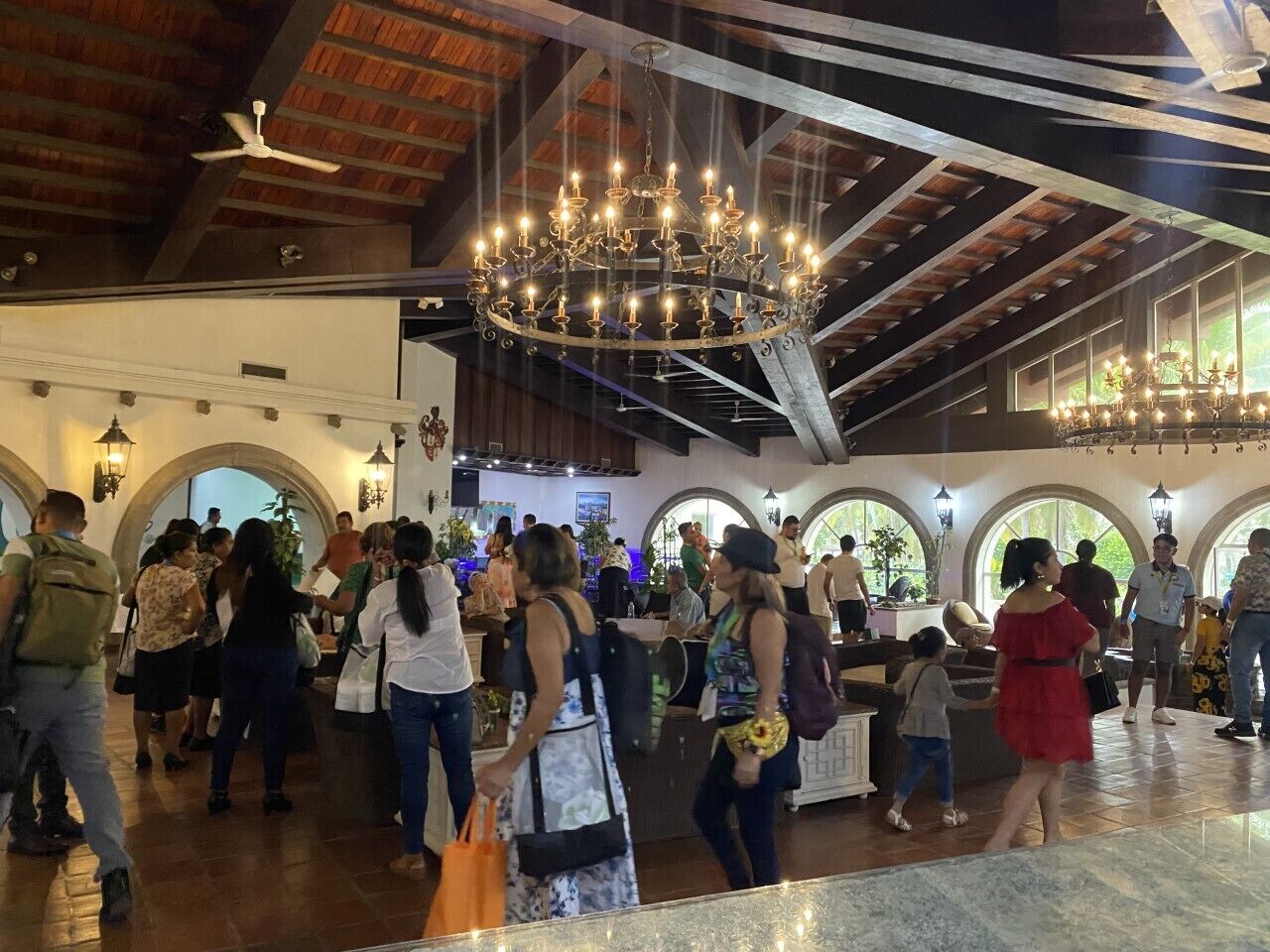 Un'ampia hall con soffitti alti, finestre ad arco e un lampadario.