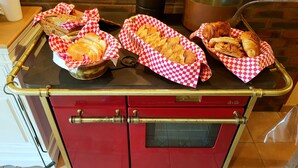 Une cuisine rouge avec des paniers à carreaux contenant du pain et des pâtisseries.