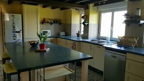 Une cuisine dotée d’un plan de travail foncé, de meubles blancs, d’un lave-vaisselle encastré et d’une fenêtre offrant une vue agréable.