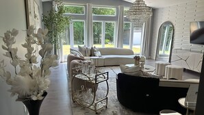 Ein modernes Wohnzimmer mit einer Couch, einem Couchtisch und einer Chandelüster.